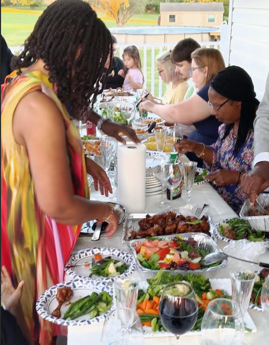 Members sharing a meal at an outdoor fellowship gathering