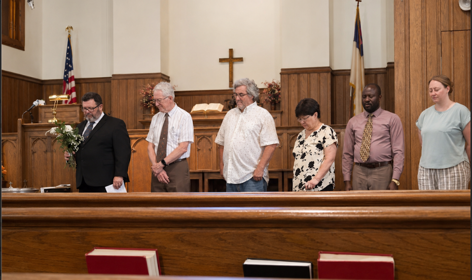 Church members standing in prayer during worship