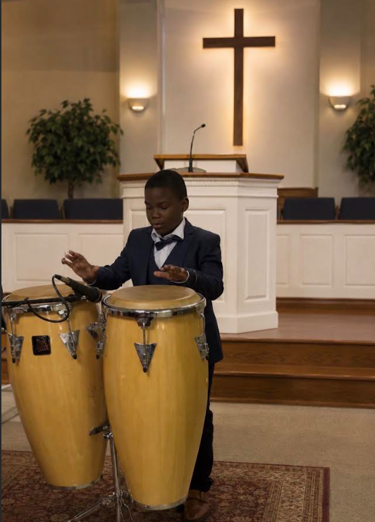 Young musician playing congas during worship service